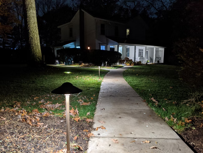 Illuminated walkway with path lighting fixtures at night